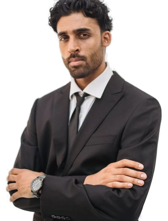 John Cruz Enos, Director and Founder of Kenneth PMC, in a suit with arms crossed
