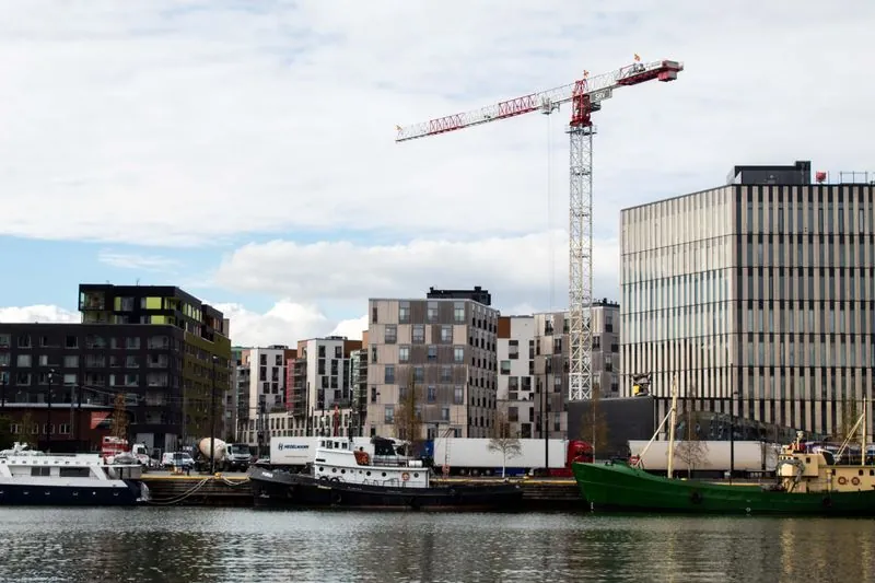 Waterfront development under construction with a tower crane