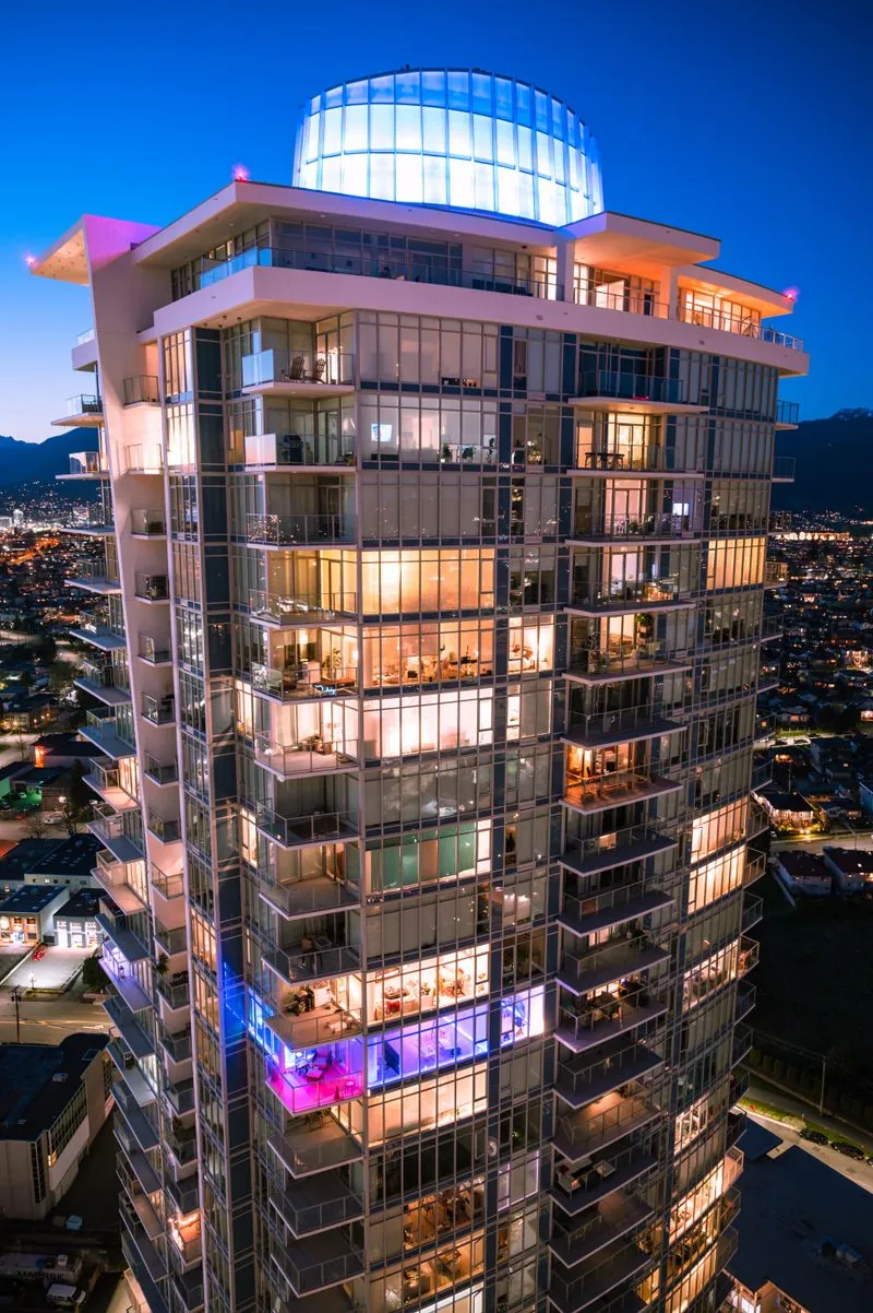 Illuminated high-rise residential tower at dusk